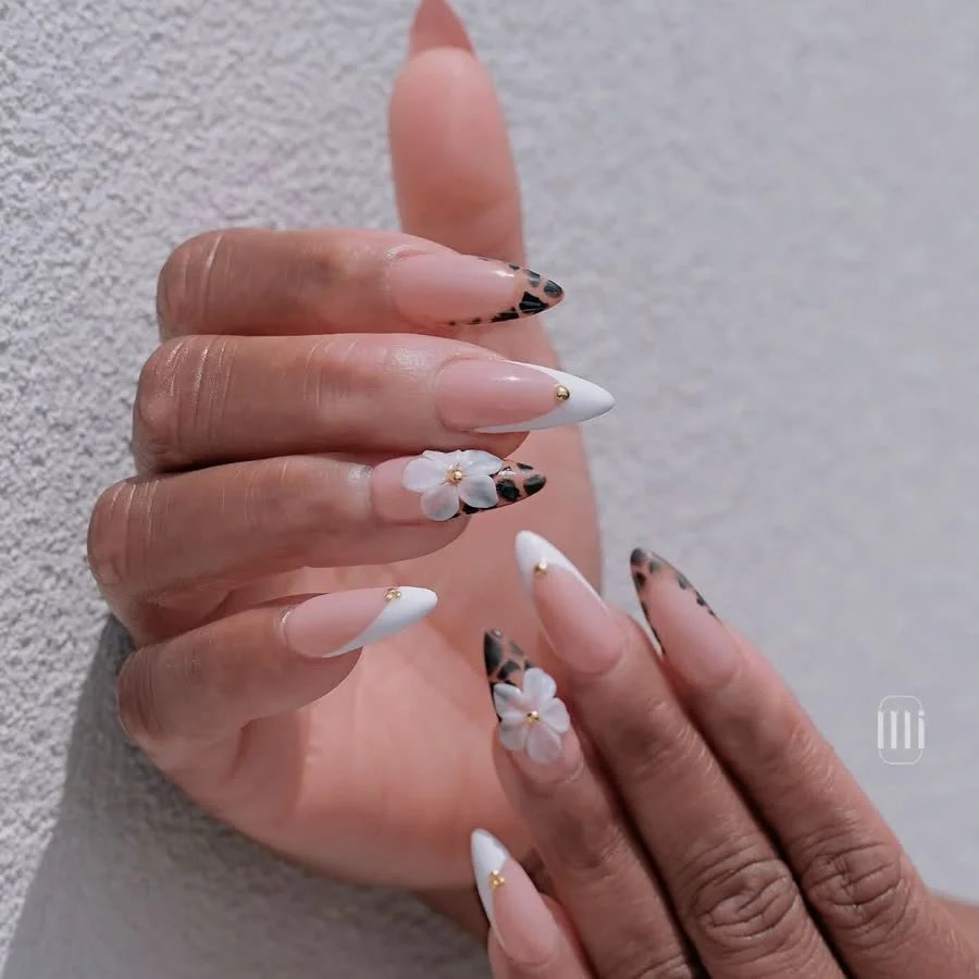 Almond nails with white French tips, leopard accents and a white flower